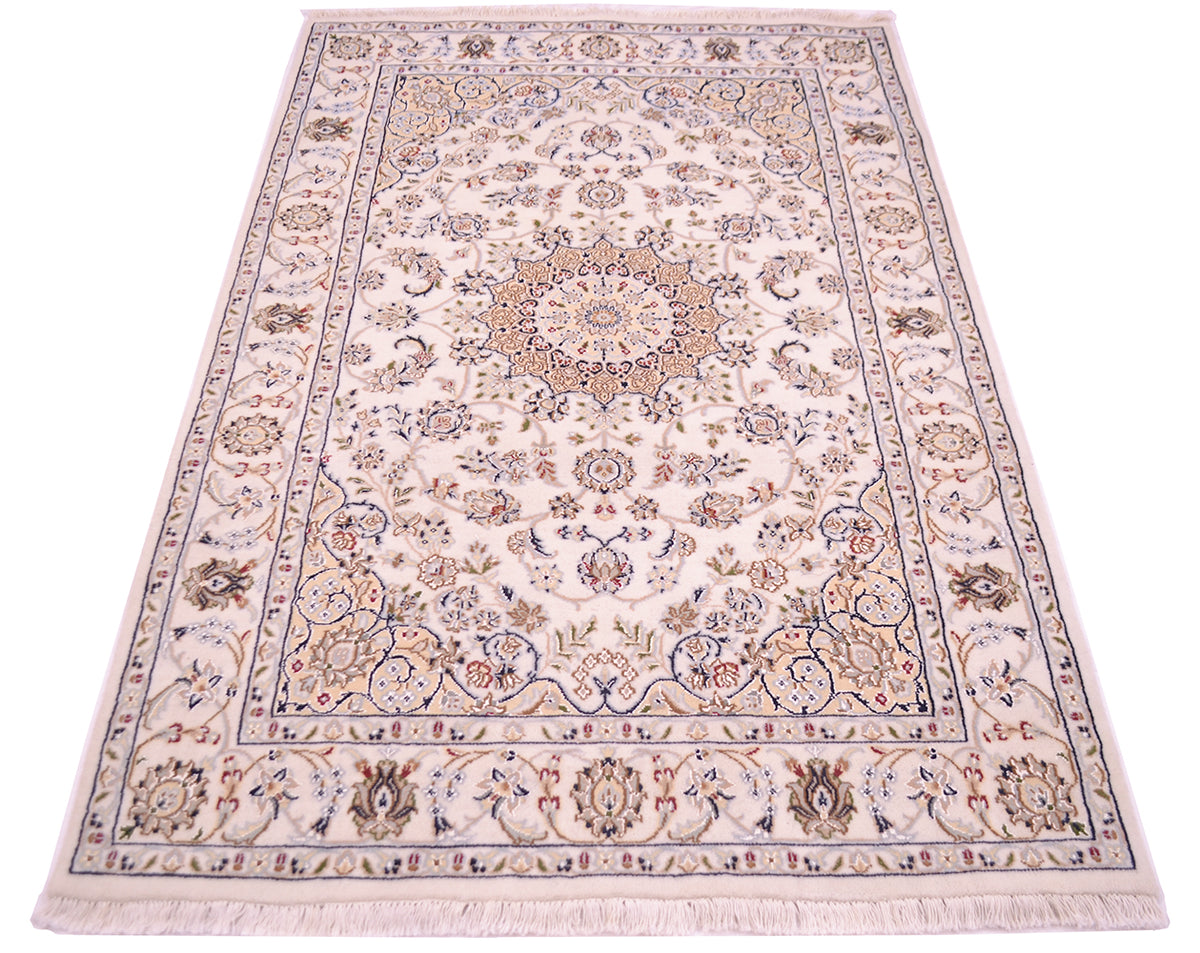 An ornate rectangular area rug with a traditional Indo Persian-style floral pattern Nain rug, featuring a cream background with blue, beige, and brown details, complete with a fringed edge.