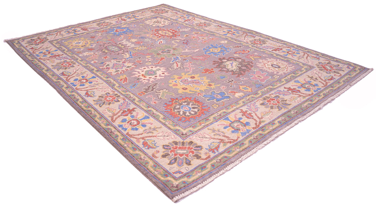Angle view with white background of Oushak Rug with added accents of soft terracottas, blues and yellow golds