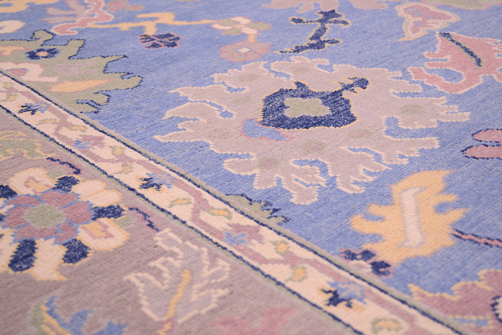 Detail of vine and flower border of Afghan Ushak carpet in blue and grey.