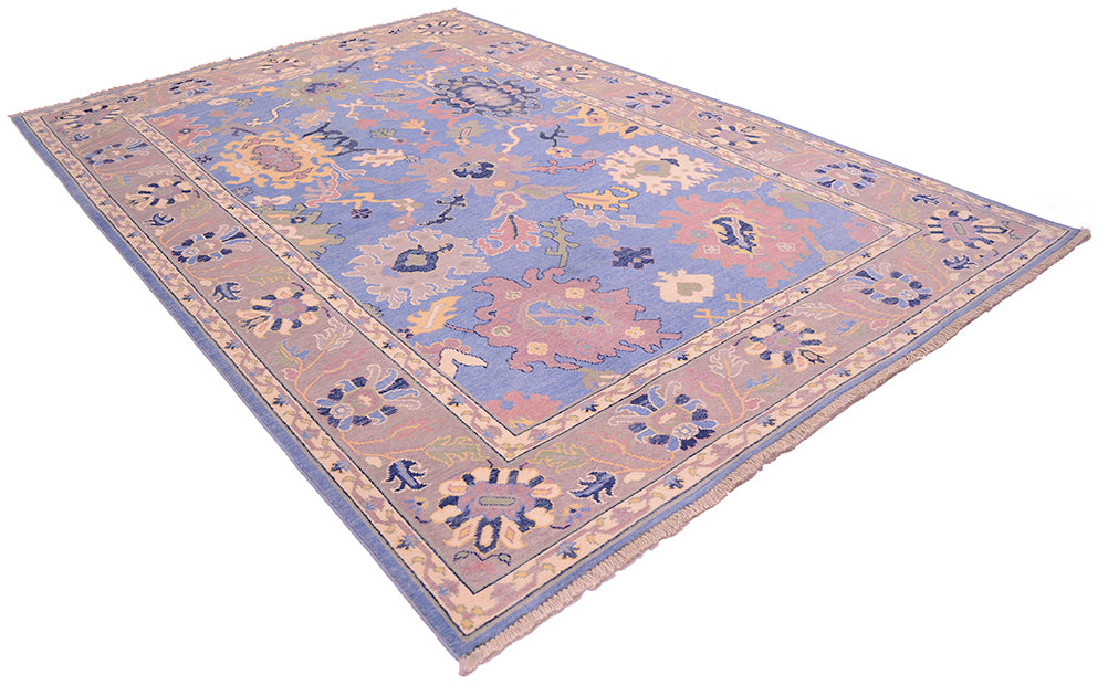 Angled view of all over floral design of handknotted Ushak design carpet