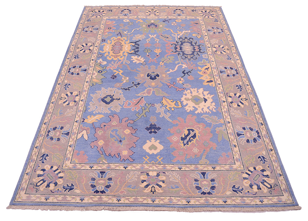 Handwoven ushak carpet with blue, grey and lilac hues.