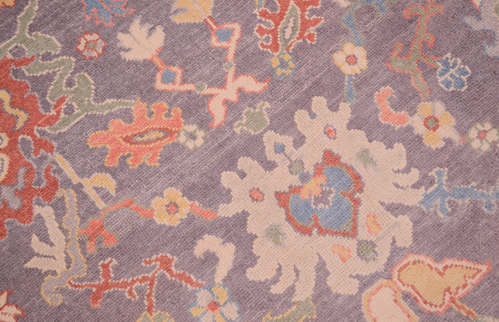 Detailed view of Ushak design carpet in terracottas, blue and green on grey field