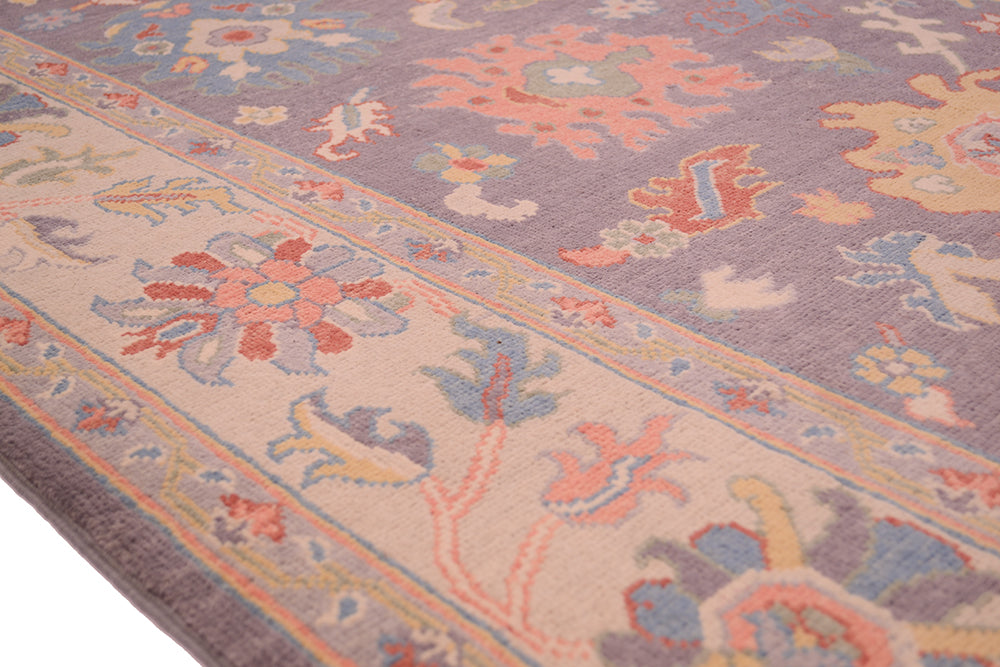 Detail of handwoven carpet cream and multicolour border in soft pastel hues.