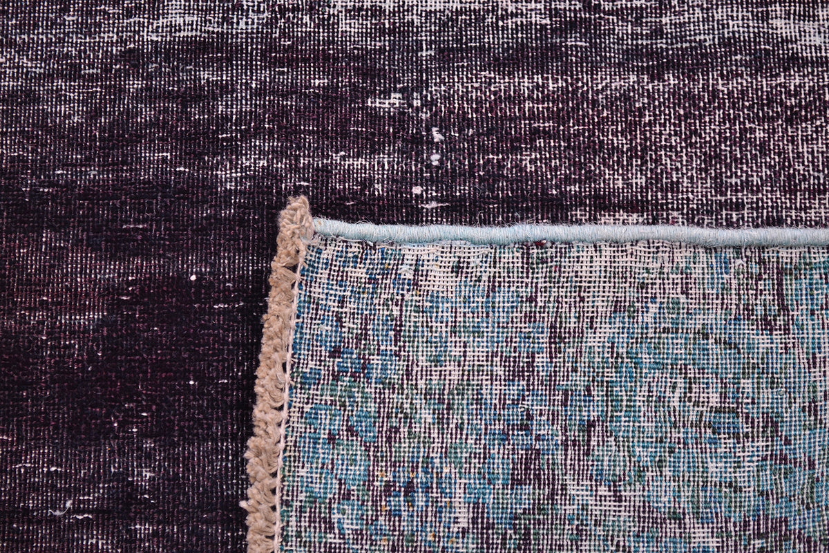 Reverse of vintage hallway runner rug showing back of rug and knots and cotton warp and wefts. Low pile-zero pile field with deep inky aubergine main field colour.