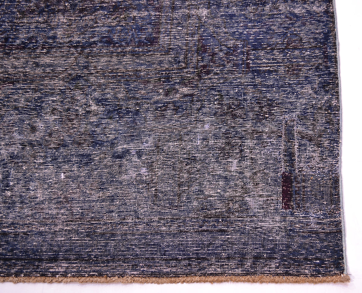 Deep aubergine and indigo tonalities of large vintage carpet with fine knotting and artisanally shaved cut pile exposing historical orginal patternign and design.