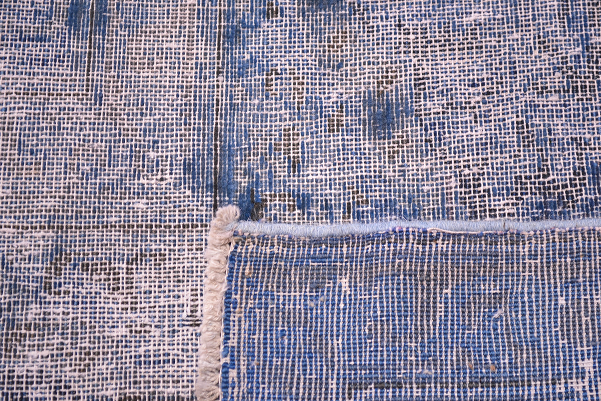 Reverse of overdyed carpet with zero pile and cotton warp and wefts in construction.
