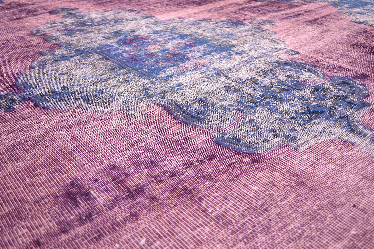 Field colour of raspberry fushia magenta field colour with centralisd medallion motif in blue and pink. Distinctive historical pattern still visible.