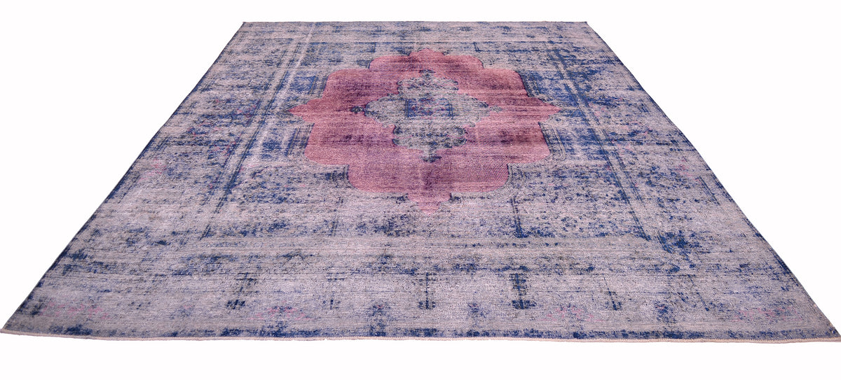 An vintage overdyed carpet with a classical oriental carpet design with vestiges of traditional border and lobed medallion in a stunning magentta Distressed handwoven pile that has been re-dyed with deep blues and raspberry pinks.