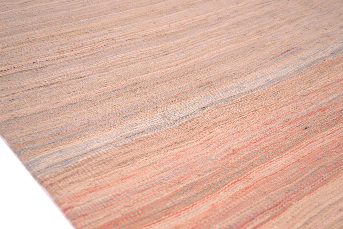 Detail of Afghan pastel abrash kilim on a white background showing variation of soft colourful tones and subtel colouration. With handspun wool with light pink, and blue-cream tones.