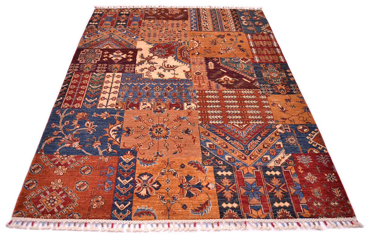 A rectangular Afghan patchwork-style area rug with an intricate multicolour geometric and floral pattern, featuring fringed edges on a plain white background.