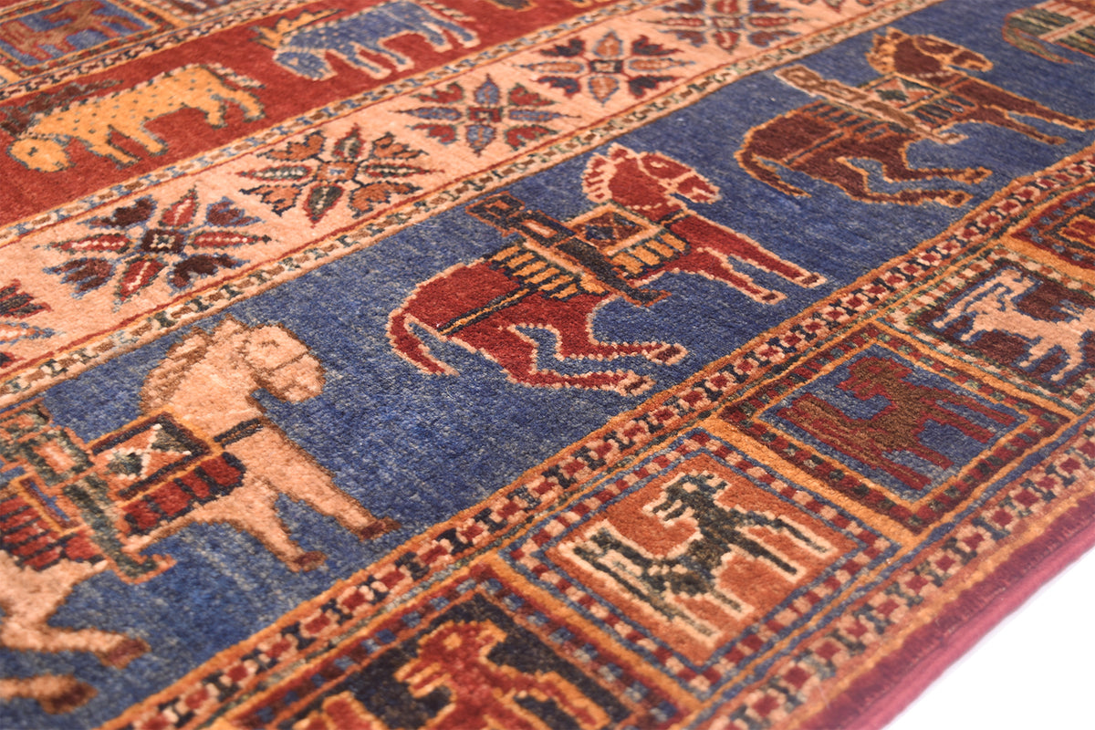 A close-up of a Handmade Afghan Pazyryk carpet featuring stylized animal motifs, including horses and dogs, in a blue field with rust red and beige borders.