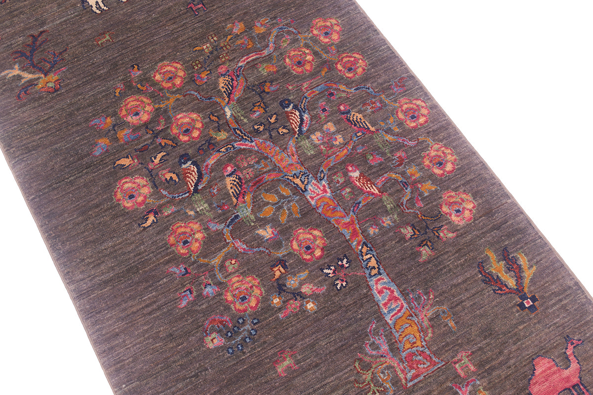 A close-up of a textured wool Pictorial grey Loribaft runner featuring a stylised tree of life motif in muted brown, pink, orange, and blue tones.