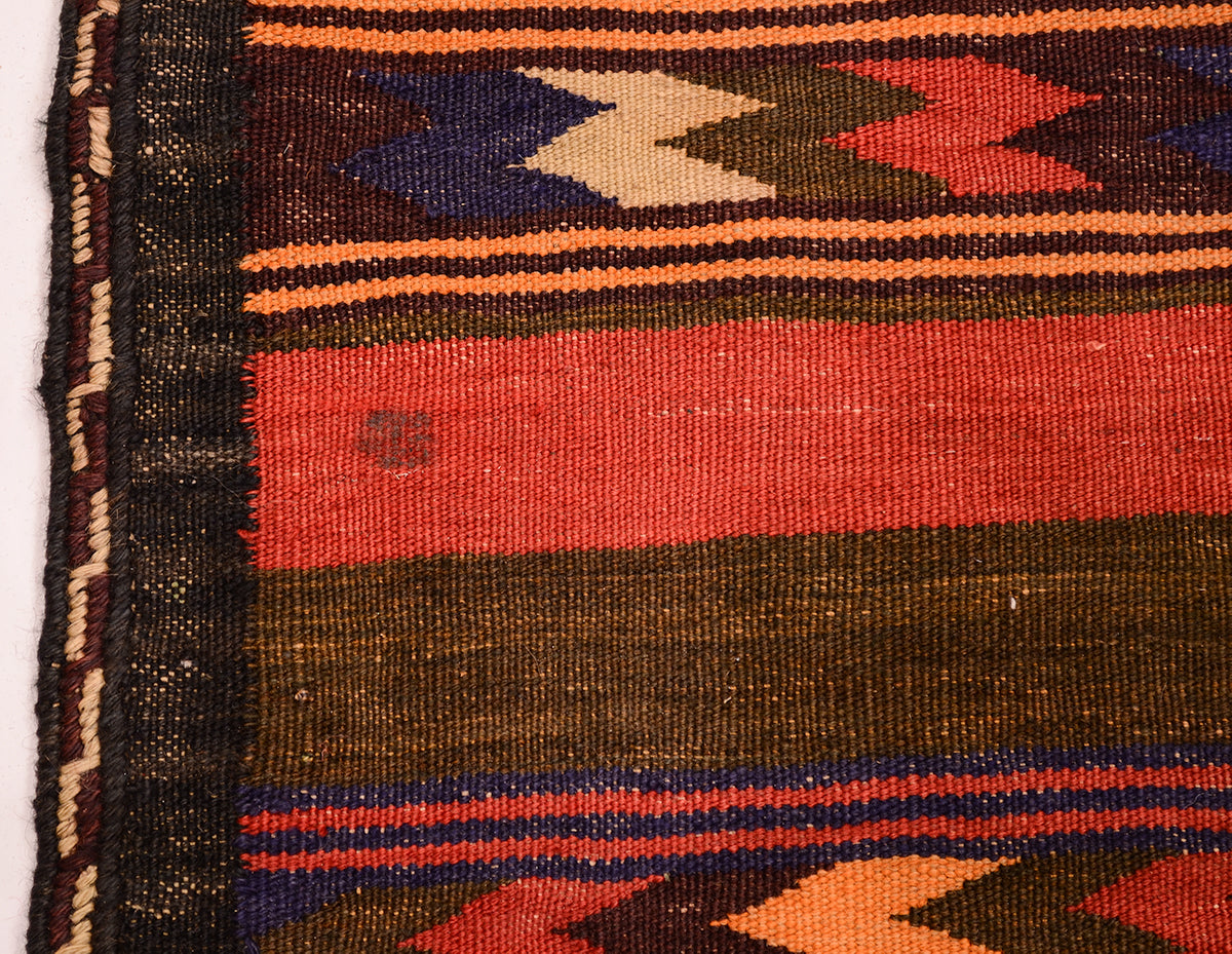 Close-up of a vintage handwoven Qala-i-Nau kilim runner rug showing a striped pattern with red, orange, dark brown, navy blue, and beige geometric accents.