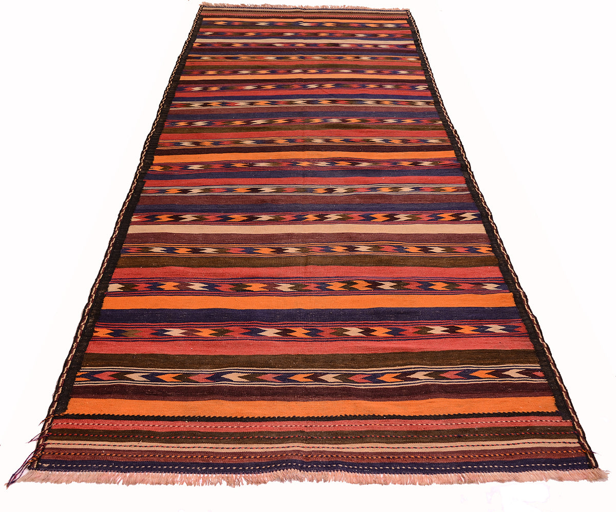 A rectangular vintage Afghan kilim area rug / wide runner with horizontal stripes and geometric patterns in orange, red, brown, black, and cream, shown flat against a white background.