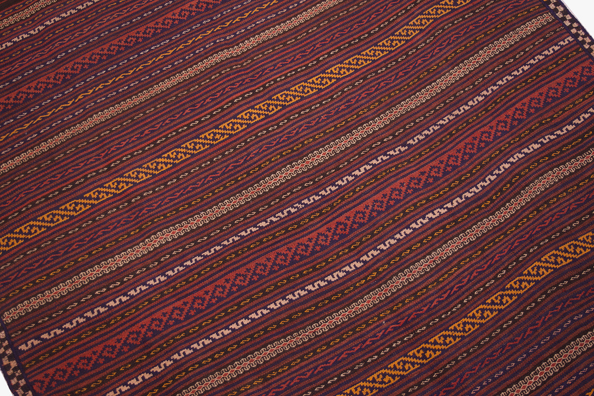 Vintage Kilim rug close-up with burgundy, navy, and yellow geometric stripe details