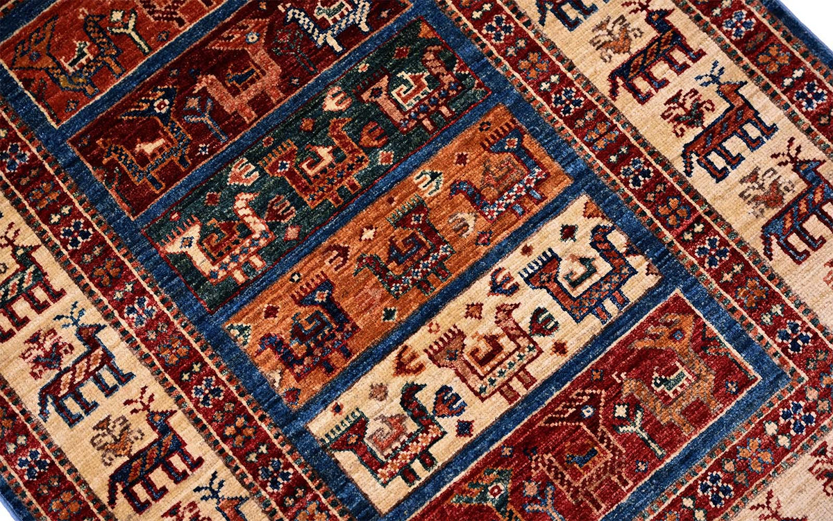 Patterned small rug with red, blue, and cream geometric motifs in bordered layout