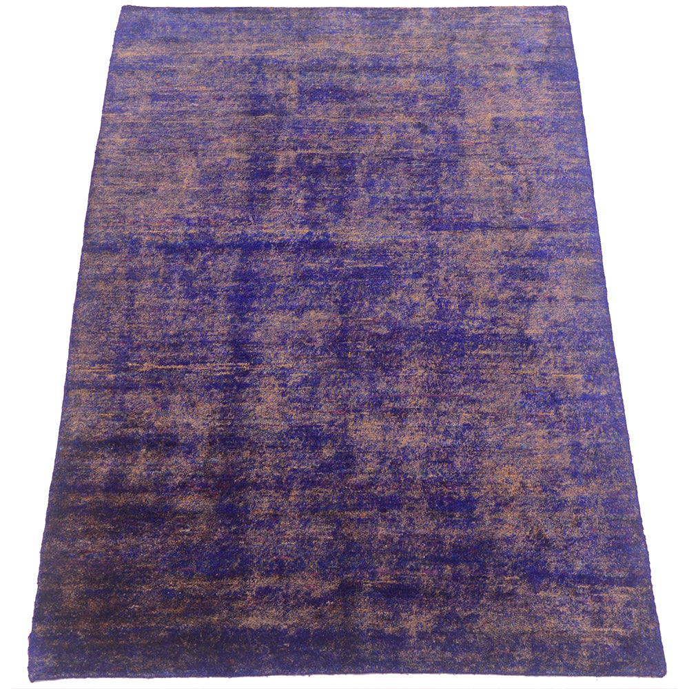 A rectangular sari silk area rug with a distressed, vintage-style pattern in deep purple and brown tones, shown flat against a white background.
