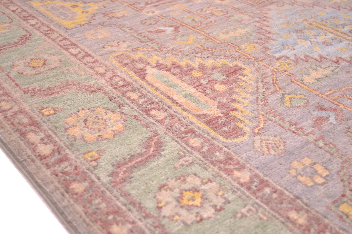 Detail of border with green background with rosette and lear design that is geometricised. Main field colour soft grey with handspun wool.