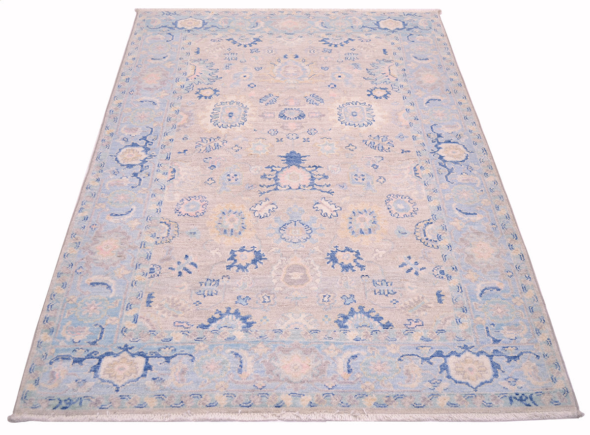 Handwoven rug inspired from designs of antique persian carpets with soft blues and greys and multiple floral motifs of rosettes and palmettes.