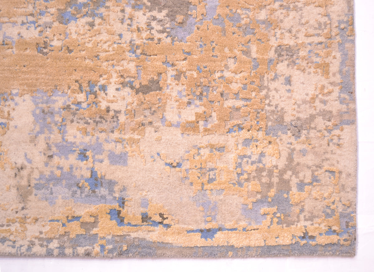 Corner detail of abstract carpet which artisanally handcut .Cotton warp threads are not visible as a bound ends. Overall area of golden cream silk. Ground base colours of light blue, light cream and light beige/cream.