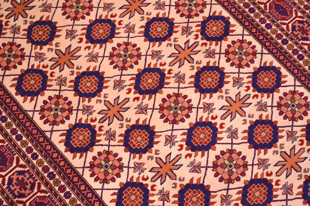 Close-up of Kabul silk and wool rug pattern: cream field with blue and red rosettes