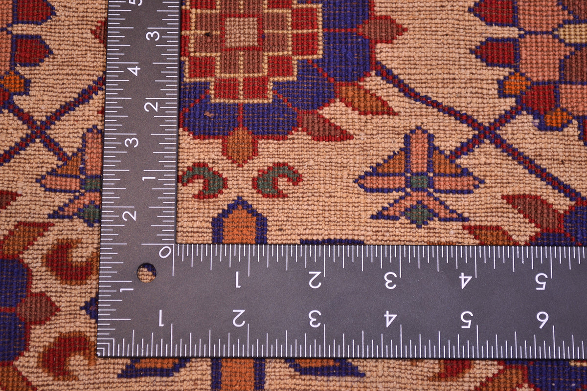 Kabul silk and wool rug close-up with measuring tape across the cream patterned surface