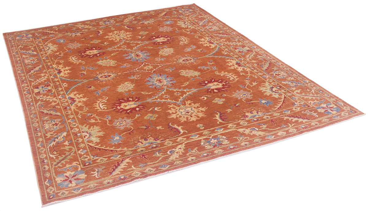 Angled view of Sultani carpet in modern colours with arabeques and scrolling vines with ornate flowerheads. Accents of red, blue and soft greens and yellows.