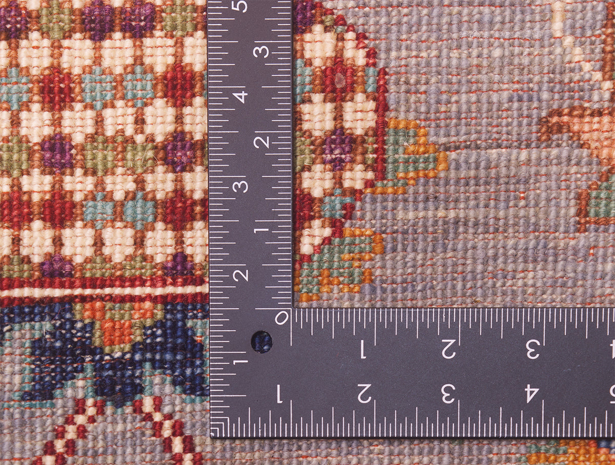 Detail of back of handknotted rug showing detail of fineknotting and use of colour as well as red warp threads.