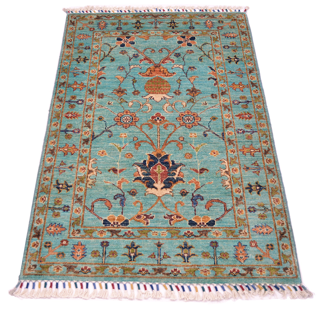 Intricate floral design showing multicoloured main field floral detailing on a light turquoise background. Cotton warps are tied and bound in a colourful fashion with woollen yarn.