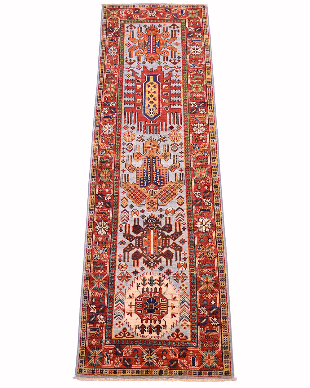 A 8ft long rectangular antique style Taimani runner with an intricate geometric and tribal pattern, featuring a pale blue field, and red borders, shown flat against a white background.