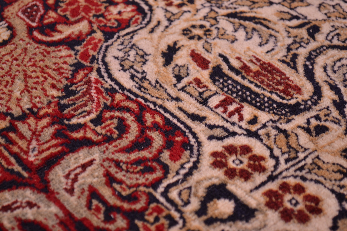 Old Belouch-Tavusi rug close-up of red and cream floral motifs with fine detailing.