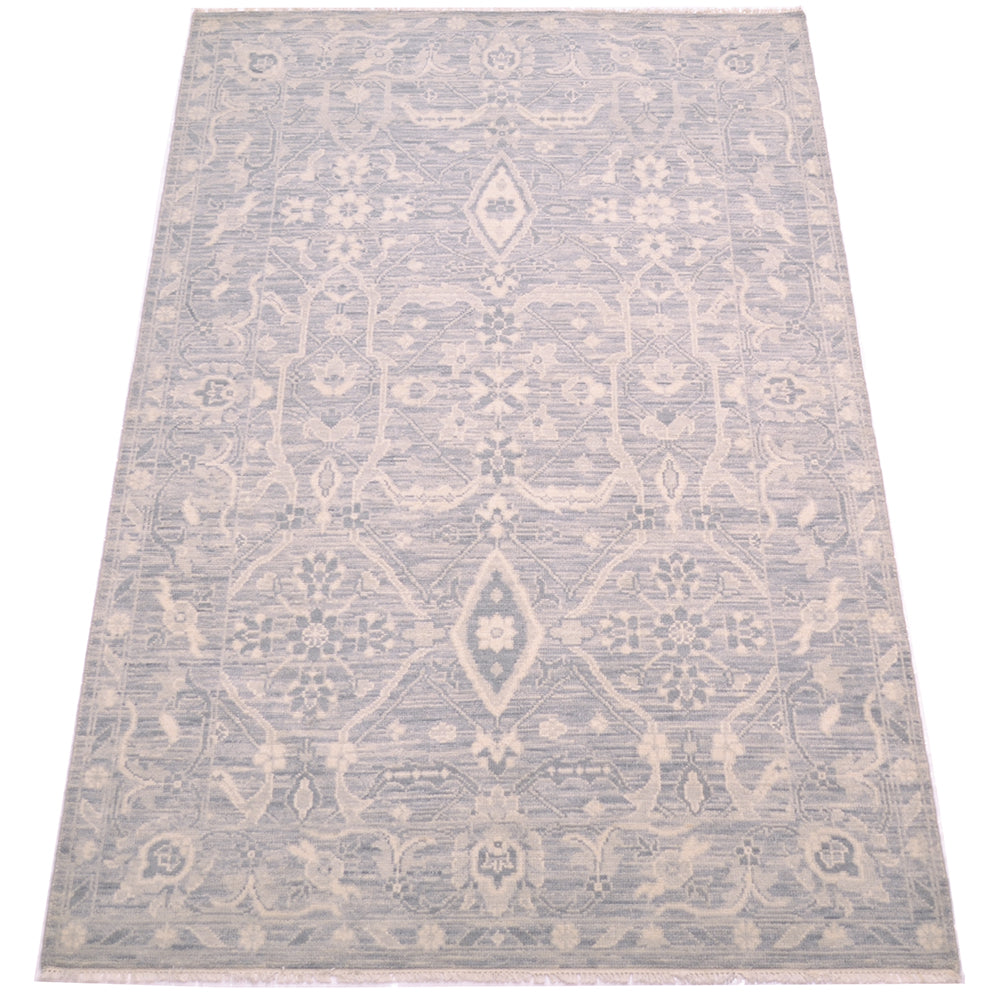 A rectangular tonal rug with a traditional geometric pattern in light grey and cream, shown flat against a white background.