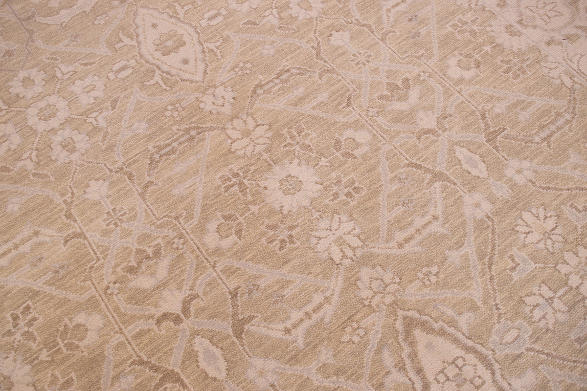A close-up of a beige and cream patterned tonal rug with a traditional floral design.
