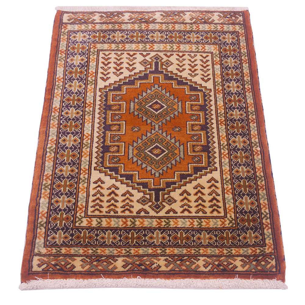 A traditional rectangular area rug mat with a geometric medallion pattern in rust orange, beige, brown, and navy blue, finished with cream fringe