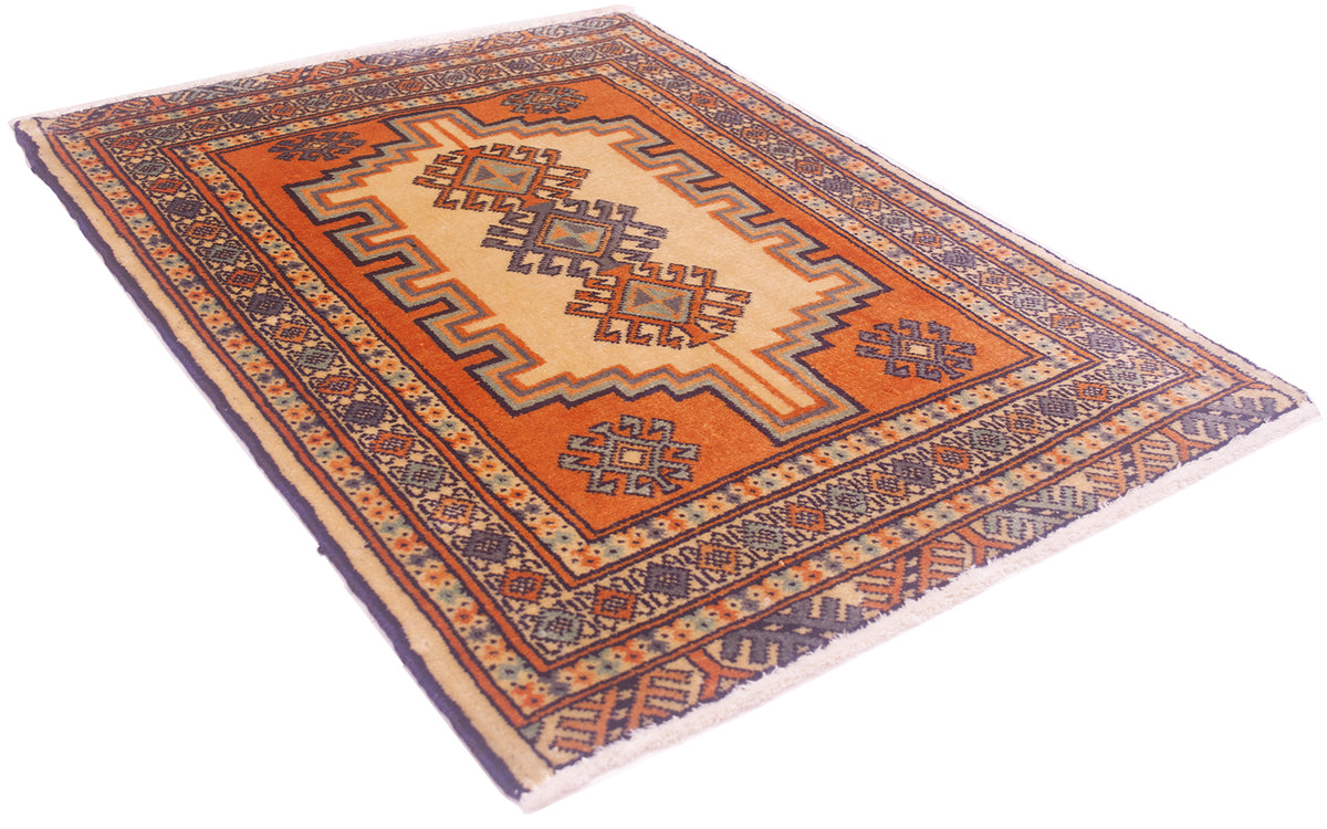 A rectangular area rug mat with a traditional geometric pattern, featuring a central orange field, beige borders, and blue accents, shown on a plain white background.