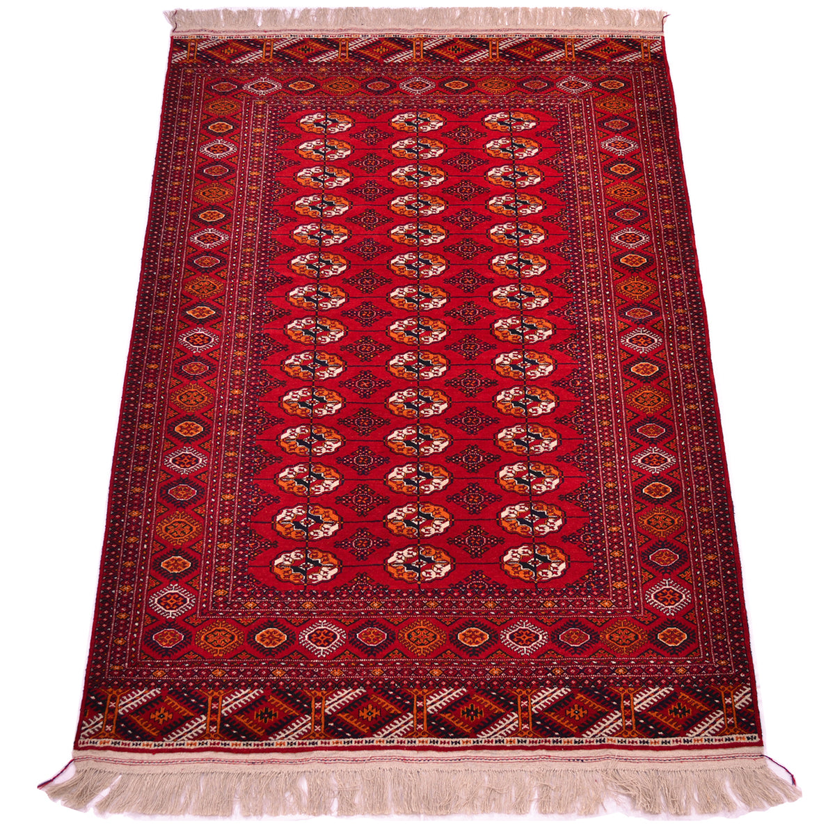A traditional oriental Turkoman Bokhara rug with a deep red field, featuring a central row of repeating Tekke gul motifs in cream, orange, and black, surrounded by ornate borders and cream fringe on the top and bottom.