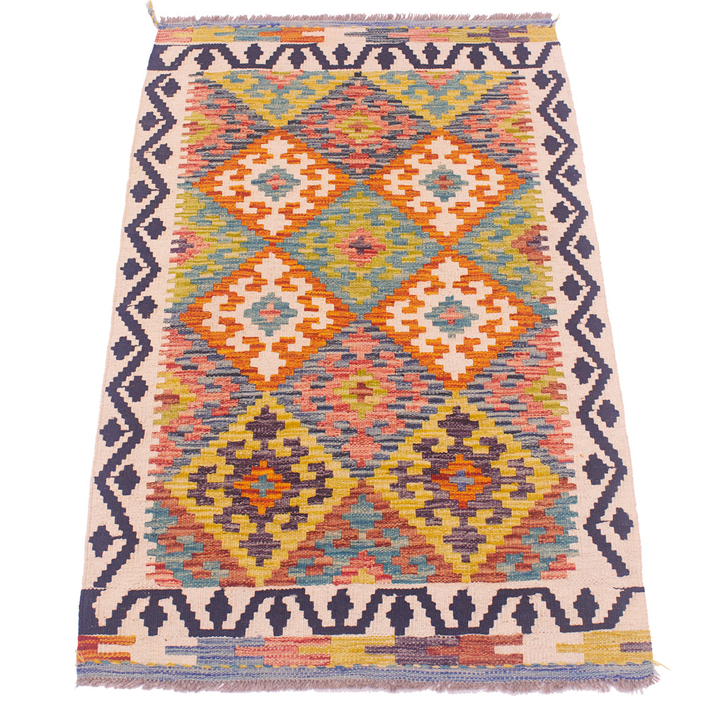A flatweave geometric kilim rug with a cream-colored base and a vibrant multicolor pattern of orange, yellow, blue, and pink diamonds, framed by dark navy borders.