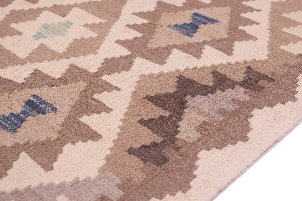 Close-up of a woven Afghan Natural Dye Kilim Runner with a geometric tribal pattern in beige, brown, and muted blue, shown on a white surface.