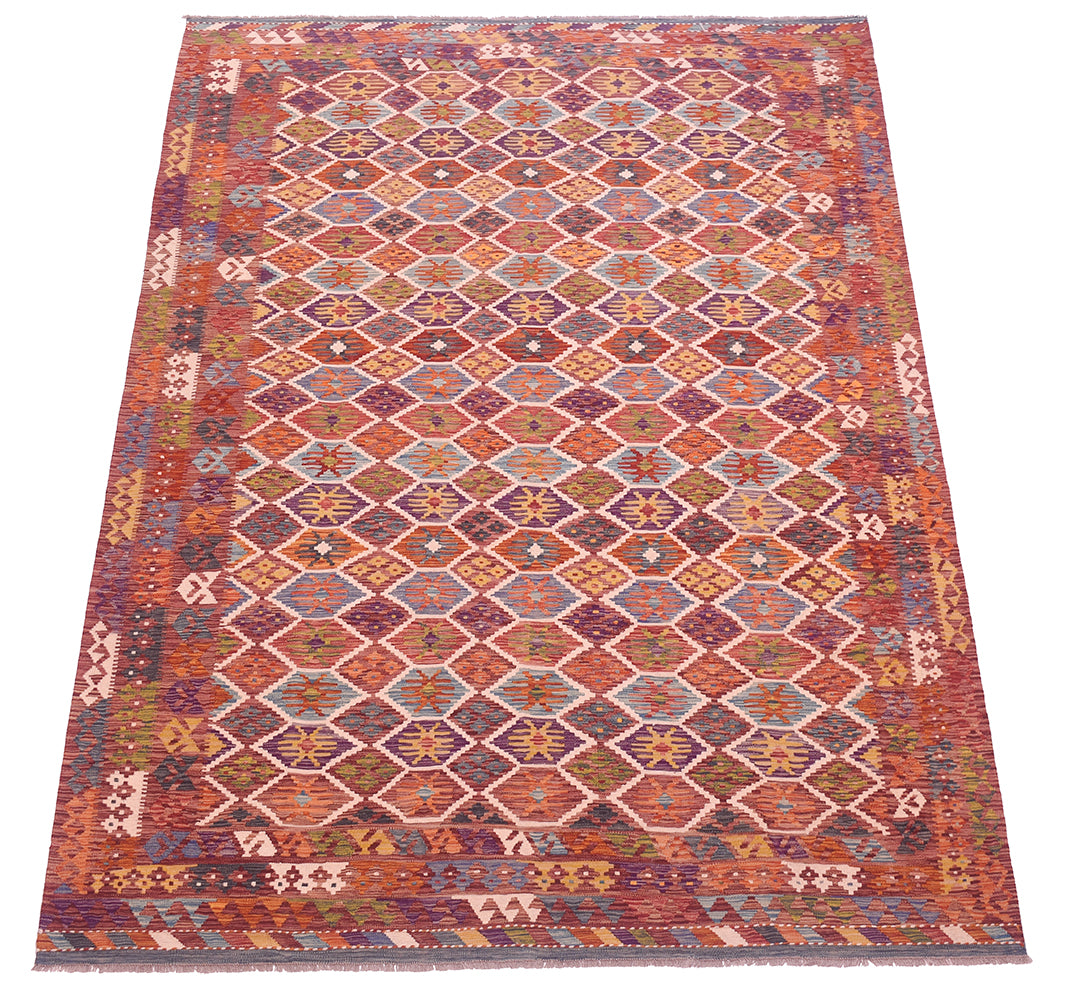 Handwoven kilim rug with stepped diamond motifs in orange, red, purple, and white.