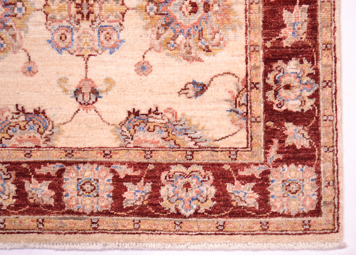 Handknotted rug with natural vegetable dyes corner motifs and border with palmettes and floral vines. Outlining of palmettes in blue and golden yellow. Creamy floral field.