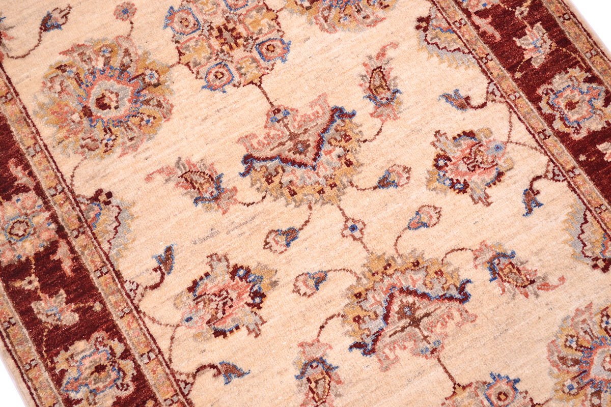 Close up and detail of Ziegler design rug with palmettes and floral blossoms. Minor borders in golden beige with a rust red border background.