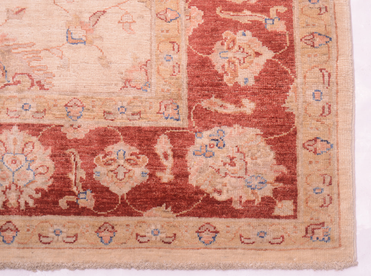 Detail of corner of handknotted afghan ziegler carpet with cotton warp fringes and palmette border.
