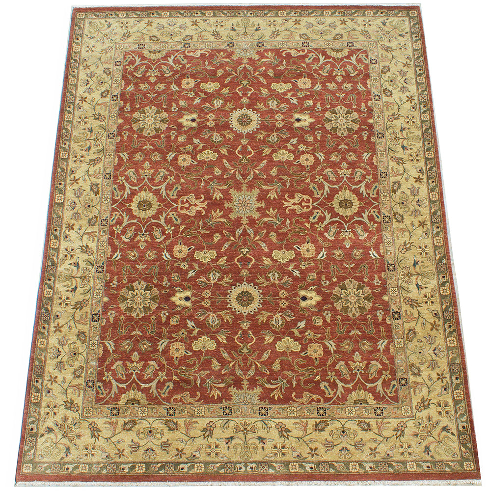 Overall view of handwoven room size carpet with Ziegler Design and flowing floral field and border. Border has beige, brown and golden olive tones. The field a warming amber rust backgrouns. With handspun wool and quality chrome dyes.