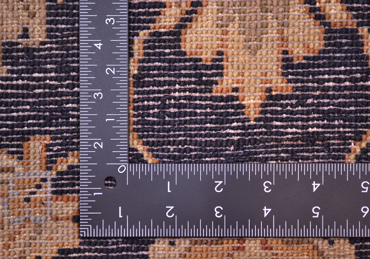 Rug close-up with woven texture and inch ruler on dark navy and tan ground