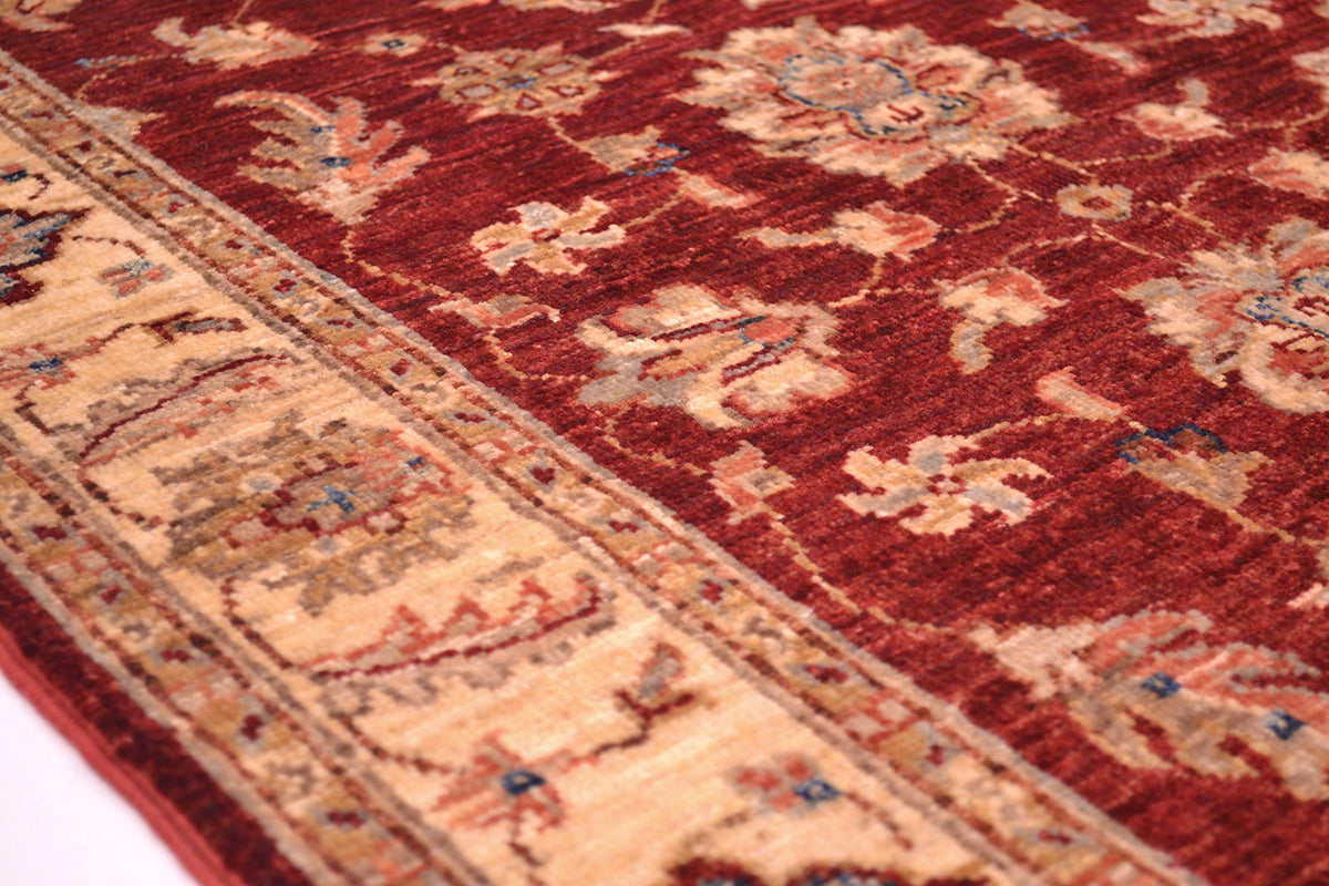 Detail of border of rug with pink terracotta and blue detailing. Handknotted with natural vegetable dyed pure wool yarn.