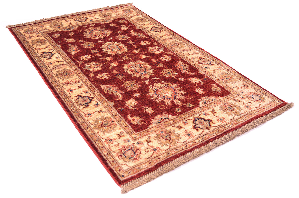 Handmade Afghan rug in traditional Ziegler floral design in rich reds and golden cream border.