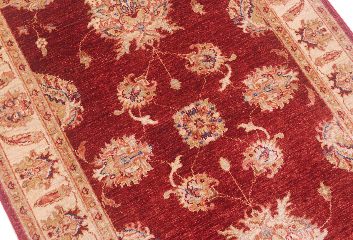 Close up of main field of Ziegler design rug with terracotta pink and blue outlining.
