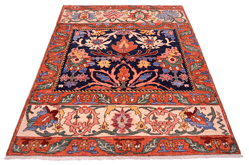 Antique floral area rug with red-orange border, navy center, and cream floral band at bottom.