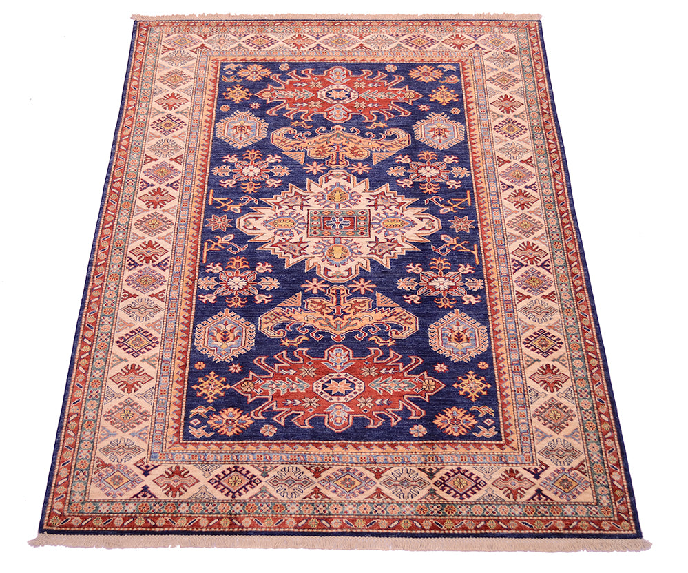 A traditional oriental area rug with a navy blue center field, featuring intricate floral and geometric motifs in red, beige, and cream, surrounded by a patterned border on a white background.