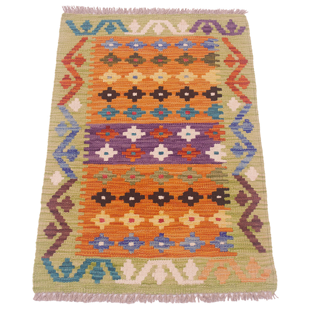 A handwoven kilim rug with a vibrant geometric pattern in orange, purple, blue, brown, and beige, featuring fringed edges on a white background.
